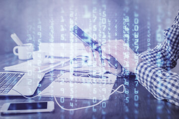 Double exposure of man's hand holding and using a digital device and data theme hologram drawing. Technology concept.