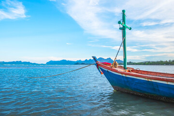 Fishing boats is moored on the seashore	sea and the beautiful sky