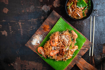 Thai food Thai Fried Noodles "Pad Thai" with shrimp and vegetables on wooden table