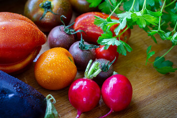 Tomaten Paradeiser Raritäten alte Sorten mit Radieschen auf einem Holzbrett und einem Messer