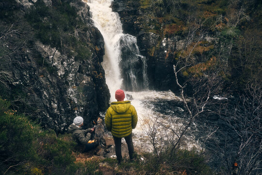 Couple of hikers, dog and waterfall 