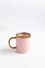 New luxury pink mug modern style with golden ring. Serving for store catalog. Isolated white background. Hot drinks tea or coffee.