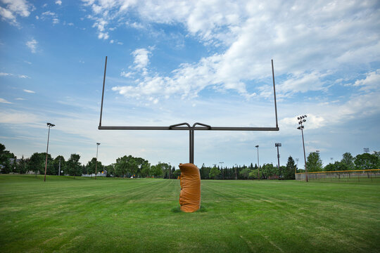 Wide angle view of a goalpost on a football field with beautiful clouds