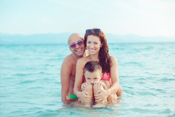 Happy family in the sea, smiling and hugging