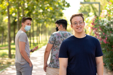 2 people with protective masks walking in the park are surprised and point to a person without a mask walking in the park and feel uncomfortable