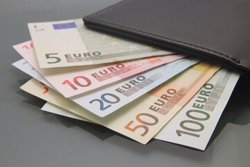 Euro currency money, euro money banknotes, various bills inside a wallet, close-up on dark background. Cash money