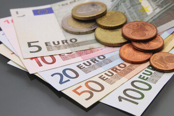 Euro currency money, euro money banknotes, various bills and coins, close-up on dark background. Cash money