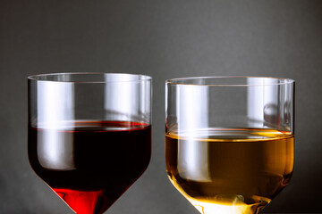 Glass of red wine and glass of white wine on gray background