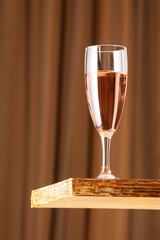 A glass of rose wine on a vintage wooden bar with copy space. Shallow depth of field. Background blurred