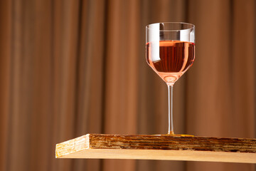 A glass of rose wine on a vintage wooden bar with copy space. Shallow depth of field. Background blurred