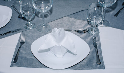 dishes with napkins on top of them, cutlery and glasses nicely decorated around them