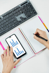 Woman holding smartphone with diagrams and charts on screen. Accountant checking annual financial...