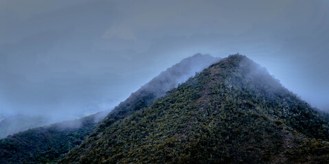
mountain with fog on the tip and going down from it