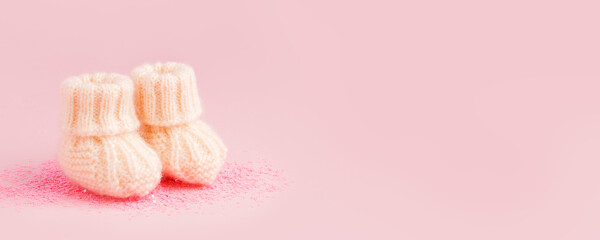 White shoes for newly born baby girl or boy on pink background, concept of expectation of baby,...