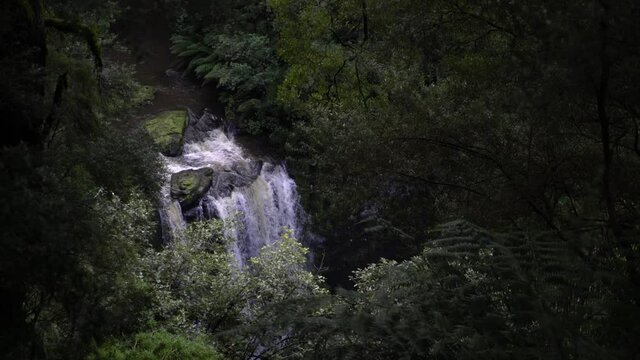 Large waterfall view from afar amongst the greenery