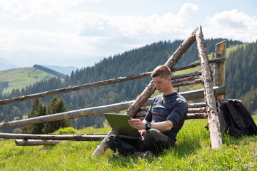 man working at laptop outdoors in nature