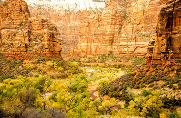 View of the Virgin River canyon from the Hidden Canyon trail in Zion National Park, Utah.  Cars are visible in the trailhead parking lot.  No sky in photo.