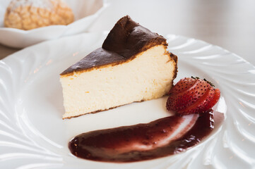 Basque cheesecake with strawberry sauce on a white dish