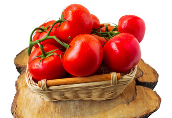 Fresh organic tomatoes with water drops in a basket isolated on white. Close up.