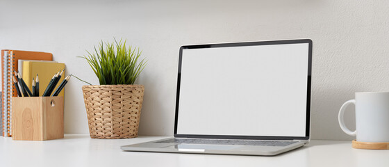 Fototapeta premium Home office with mock up laptop, stationery, books, and decoration on white desk