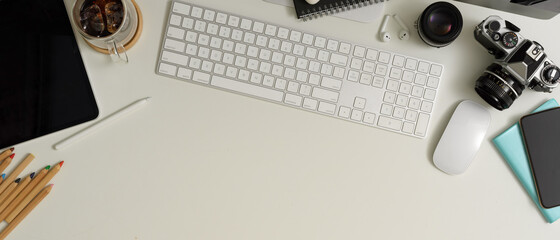Worktable with copy space, computer device, smartphone, tablet, camera and stationery on white table