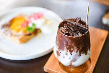 cocoa drink and chocolate / tasty milk shake with ice cocoa in glass on wood background