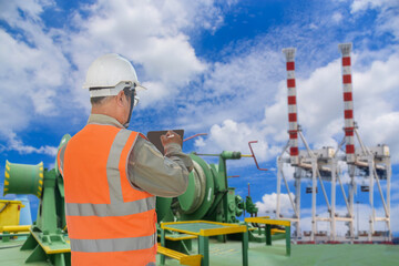 worker on cargo ship, Engineering is using the tablet on crane port background.