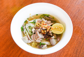 delicious noodles bowl close up of vermicelli noodles soup spicy with pork stew vegetable and lemon in bowl traditional thai and chinese style food of asia , Pork offal , Liver pork intestines