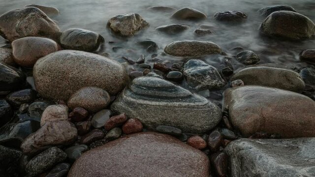 Zooming out time-lapse video.Waves flashing on seashore rocks .