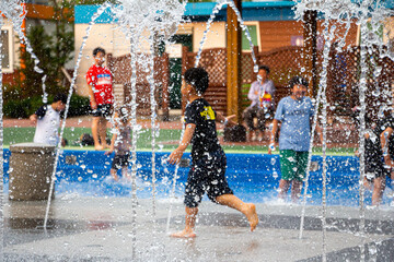 children cooling off in the fountain of the square(Blurry background with focus on fountains)