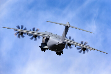 Fototapeta na wymiar Military cargo plane climbing into the blue sky.