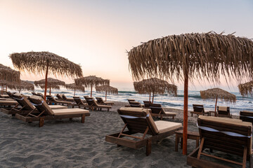 Sun loungers with umbrella on the beach, sunrise.