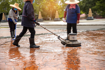 Group of  Woman worker cleaning the floor with polishing machine outdoor