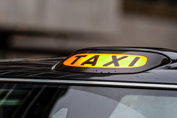 Fototapeta premium A british london black taxi cab sign with defocused background