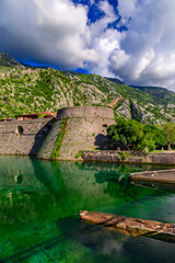 Fototapeta na wymiar Emerald green waters of Kotor Bay or Boka Kotorska and the ancient wall of Kotor former Venetian fortress in Montenegro