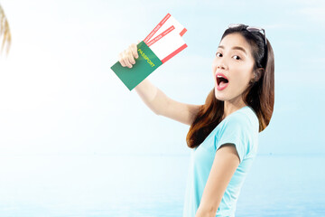 Asian woman holding ticket and passport on the beach