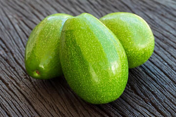 Fresh raw avocado on dark wood background, selective focus.