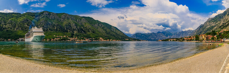 Fototapeta premium Panorama of Kotor Bay with a cruise ship and mountains reflecting in the water, Balkans on Adriatic Sea in Kotor, Montenegro