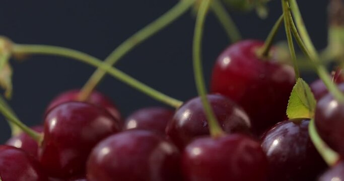 Macro shot of a cherry. Fresh, juicy, organic, natural, red cherries spin on a black background.