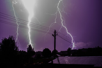 A bright flash of lightning against the dark purple night storm sky>