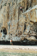 giovani ragazzi praticano free climbing su una pareta rocciosa naturale