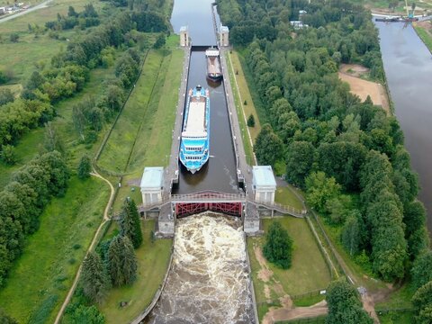 Aerial view river passenger ship passes through locks on the river channel. Tourist routes on rivers and canals