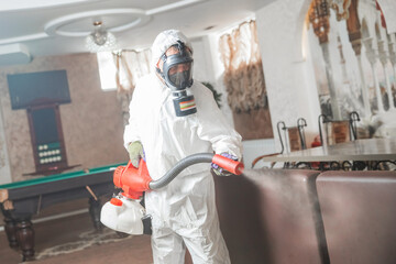 Pest control specialist in white hazmat contractor working in flat and hotel