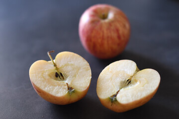 Apple cut in two halves and a full apple