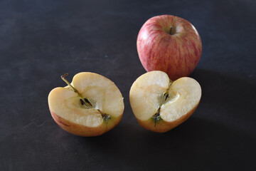 Apple cut in two halves and a full apple