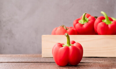 red bell peppers in a wooden box on the table