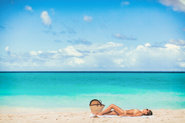 Beach vacation summer suntan girl relaxing sunbathing on blue ocean background.