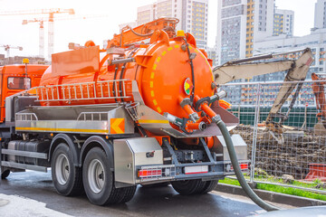 Pumping water from sewage canals during the construction of roads in the city. Truck with orange...