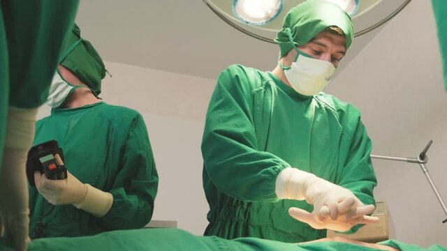 Interracial of professional doctor and nurses making cpr by AED.