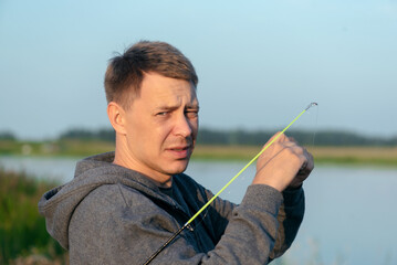 Fisher with fishing rod outdoors.